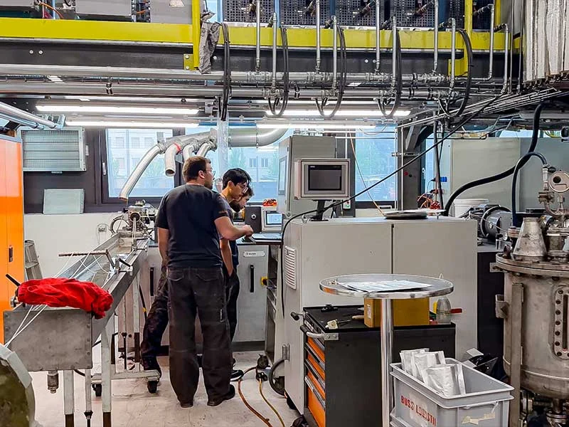 buss-technikum_pratteln-schweiz_prozessentwicklung_compoundier-system Mitarbeiter im BUSS Technikum in der Schweiz betrachten gemeinsam Testergebnisse und prüfen den Compoundierablauf im Process Engineering vor Ort.