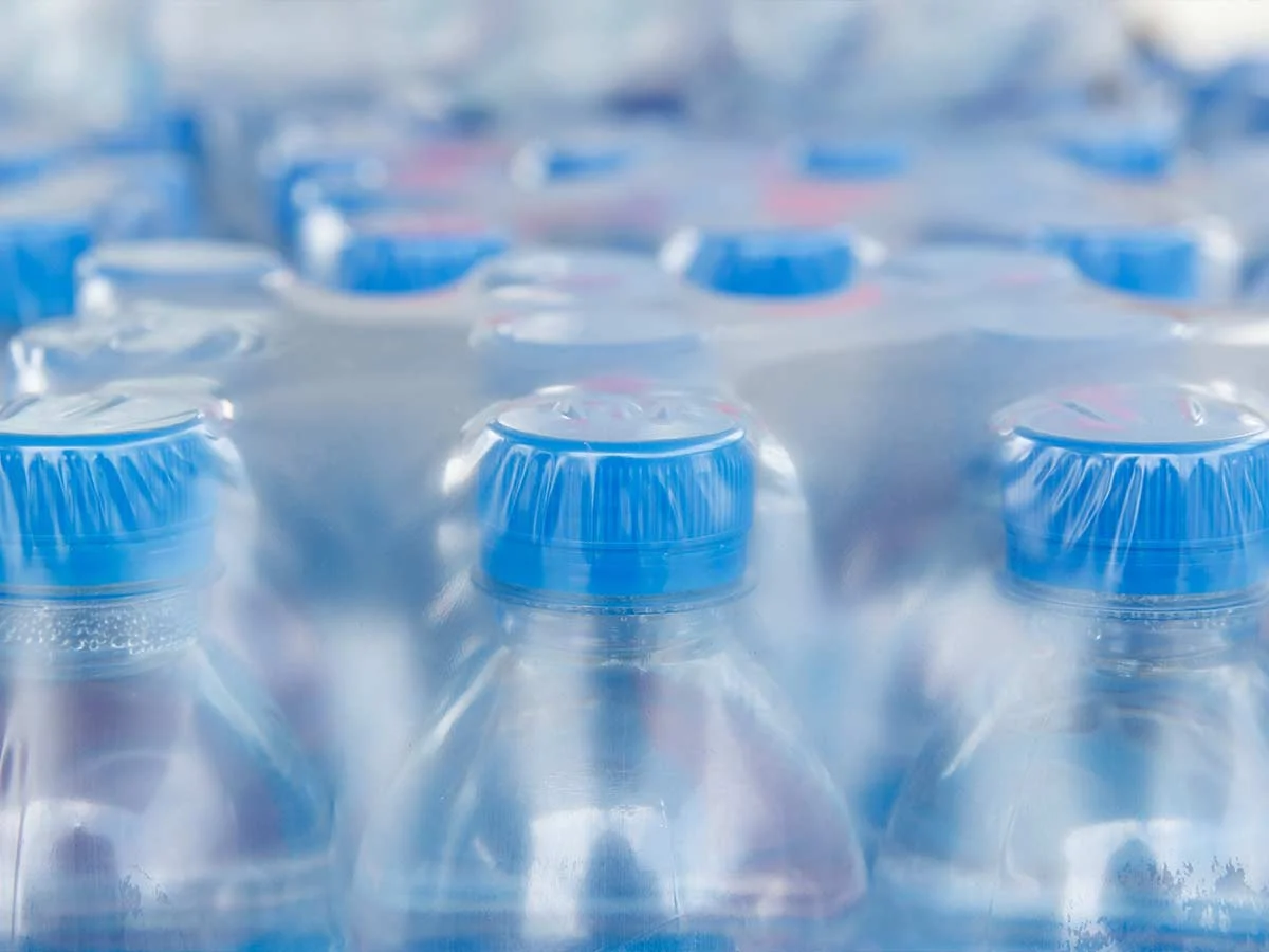 industries_bio-plastics_water-bottles Viele Wasserflaschen mit blauen Verschlusskappen.