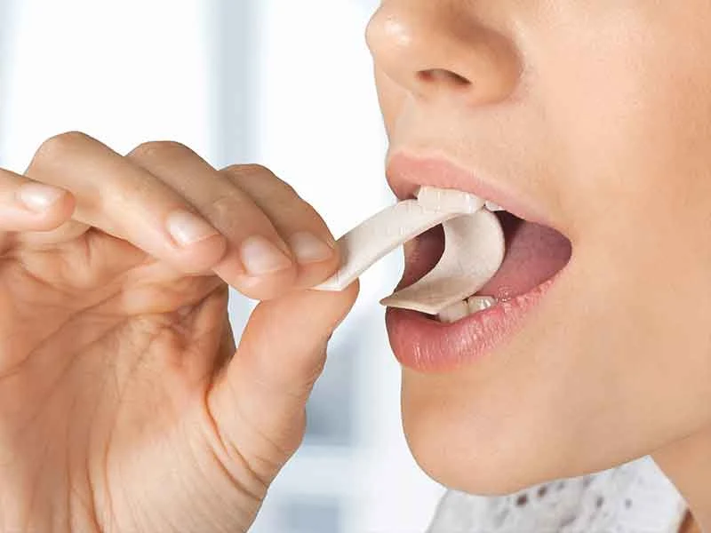 Woman chewing chewing gum manufactured with gum base
