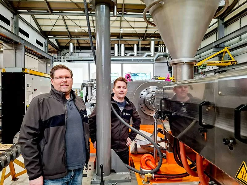 karriere_zwei-kollegen-neben-compeo_jobs-bei-buss Two colleagues from the BUSSLIST Group are standing next to a COMPEO co-kneader.